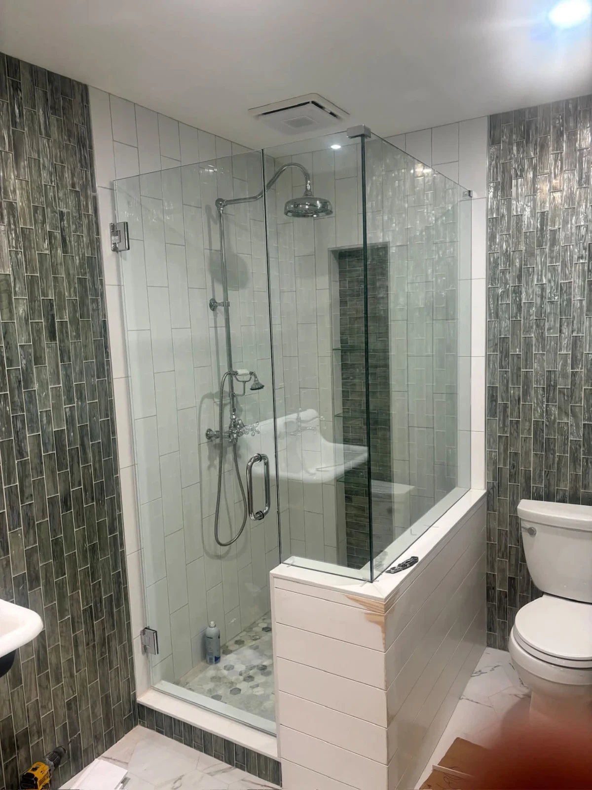 Custom frameless glass shower with carefully aligned tile and rain shower fixture